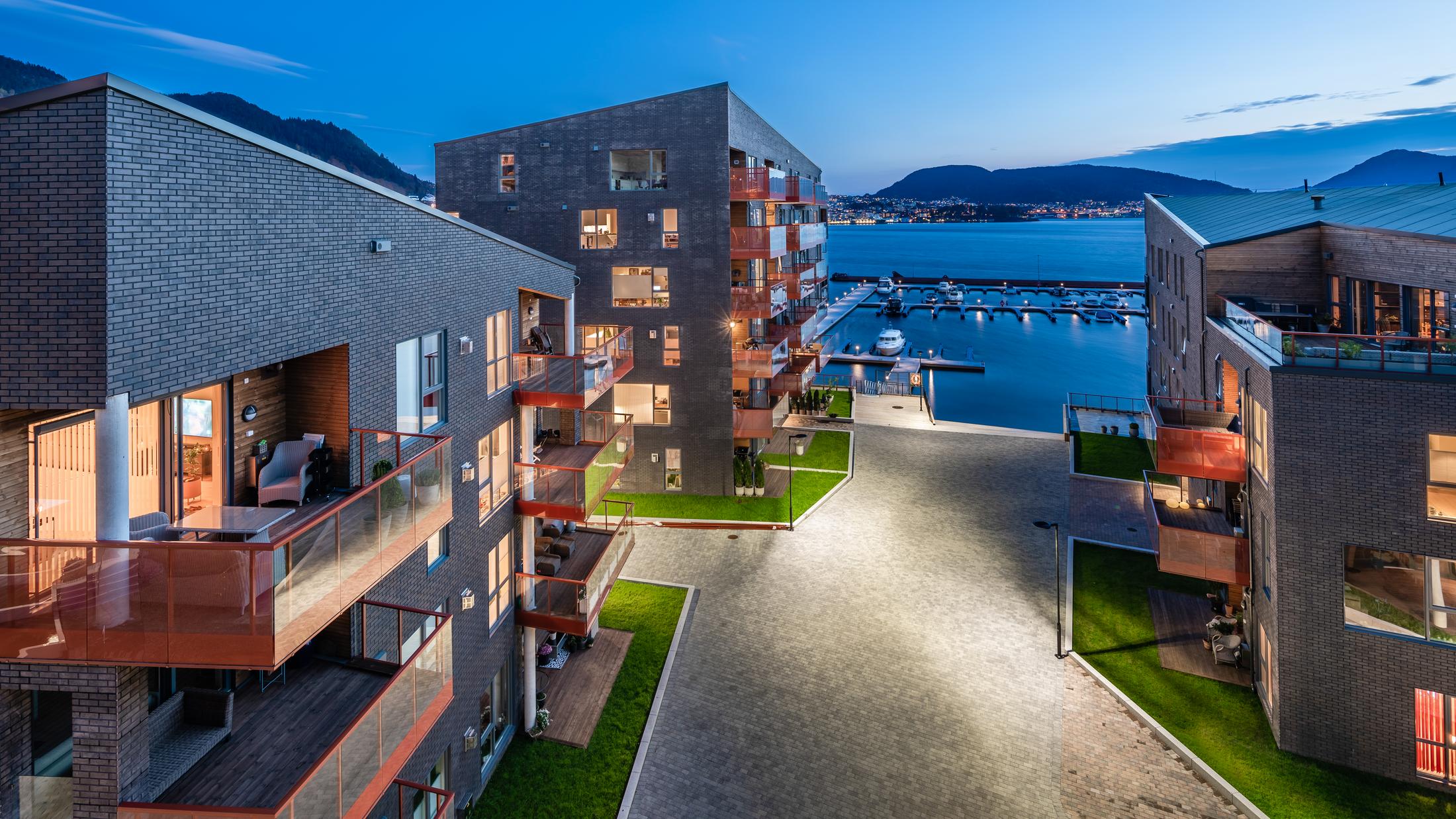 Tre boligblokker langs fjorden. Foto
