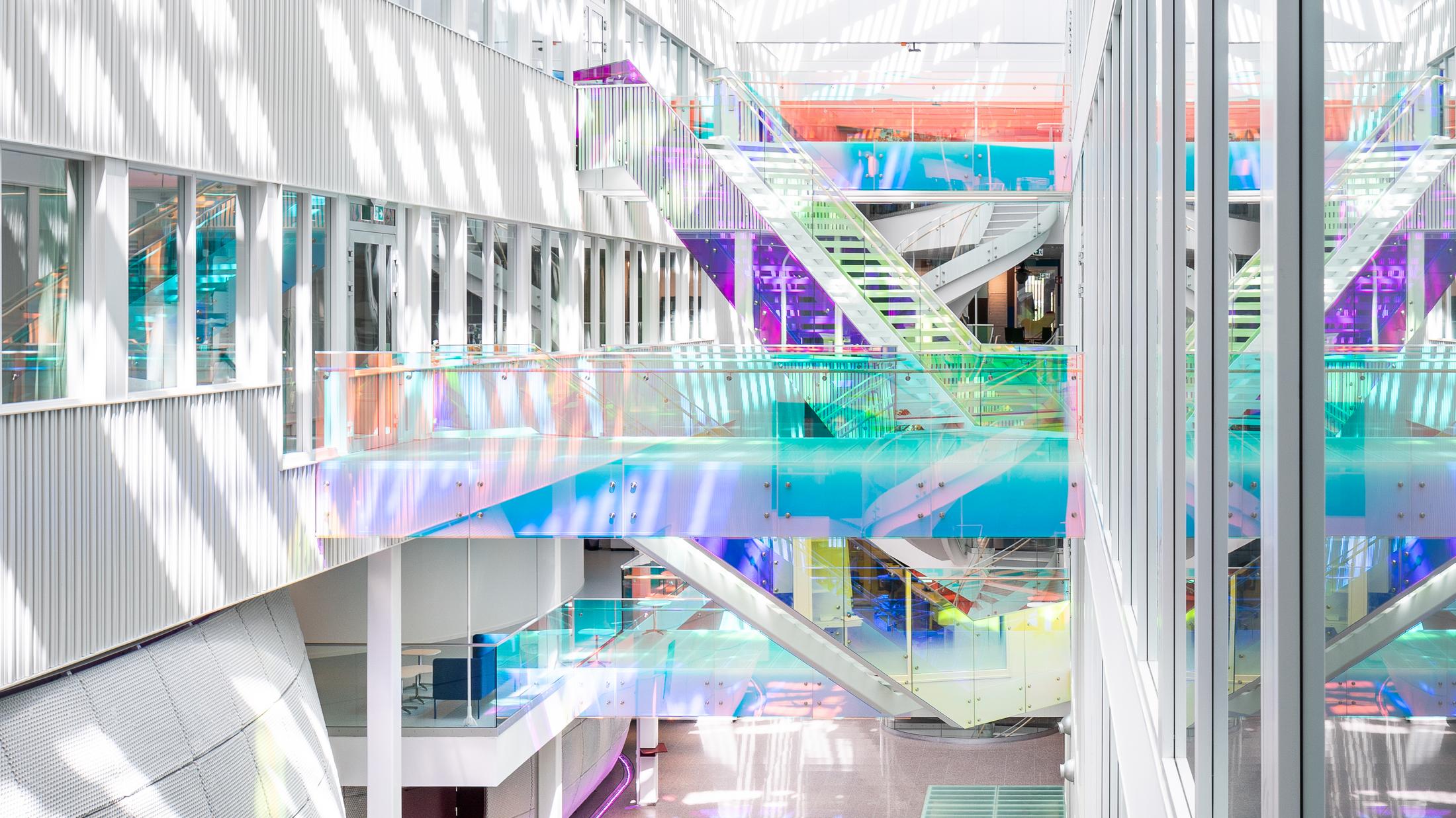 Öppet atrium med färgglada trappor. Foto