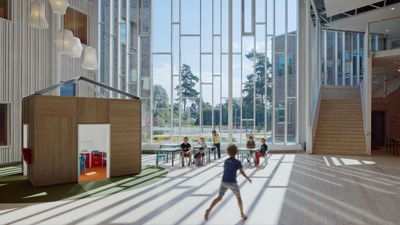 Children play in common area with large windows. Photo