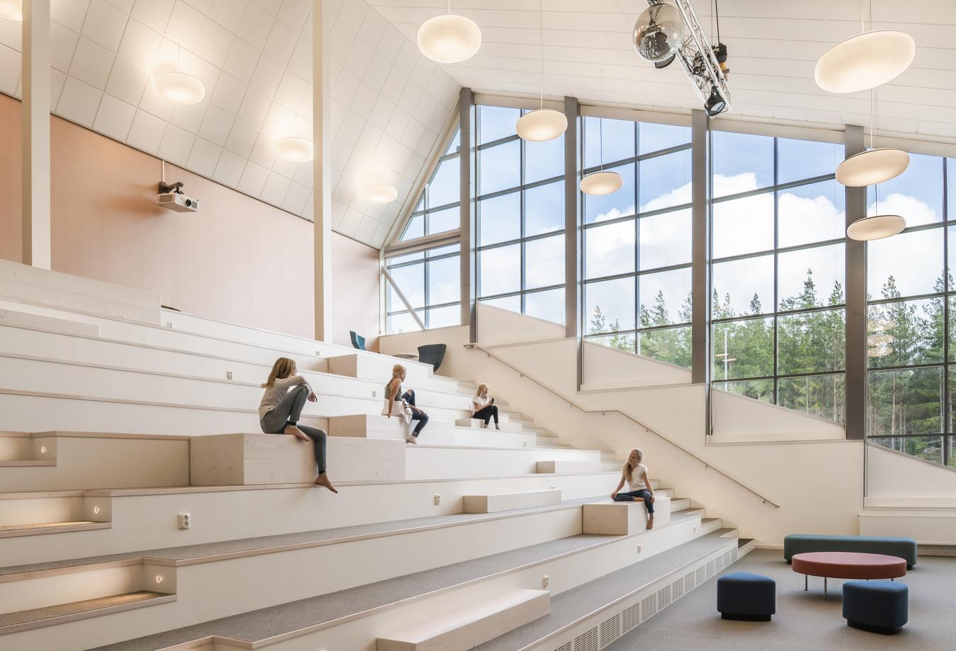 Auditorium stairs with students. Glass windows with a view on the green surrounings. Photo